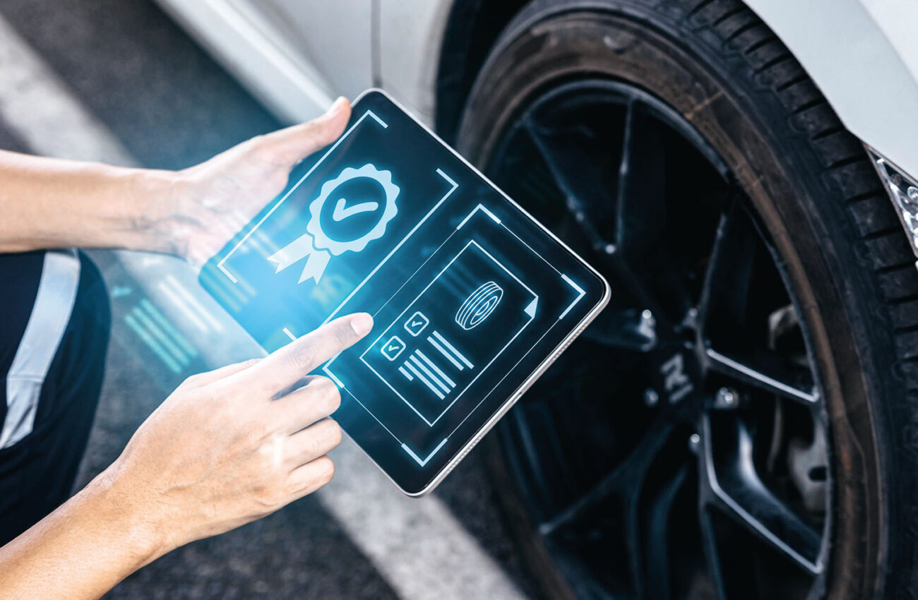 Mechanic technician holding tablet and checking to car tire in a